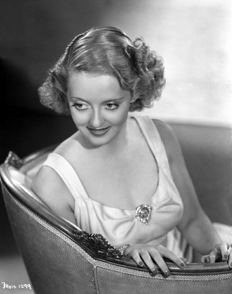 Posterazzi: Bette Davis Seated on a Couch with Hand on Lap in White ...